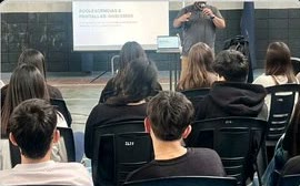 Encuentro educativo con personas sentadas frente al expositor